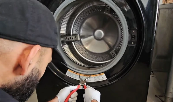Appliance service technician repairing a washer in Abilene, TX