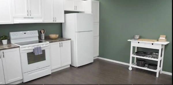 Technician repairing a refrigerator in an Abilene, TX kitchen